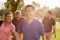 Group Of Golfers Walking Along Fairway Carrying Golf Bags Royalty Free Stock Photo