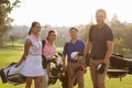 Group Of Golfers Walking Along Fairway Carrying Golf Bags Royalty Free Stock Photo