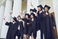 A group of graduate students raised their hands with diplomas up Royalty Free Stock Photo