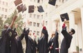 A group of graduates throwing graduation caps in the air Royalty Free Stock Photo