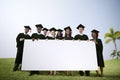 Group Graduating Students Outdoors Holding Placard Concept