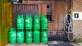 Group of green gas tank with wooden background putting near water pipeline and entrance toile or washroom.