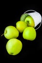 A group of green Granny Smith and golden apples in a white bucket against a dark brown background, copy space for text Royalty Free Stock Photo