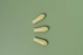 Group of green rectal suppositories for anal or vaginal use on background. Pills for alternative medicine, lowering