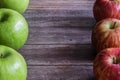 a group of green and red apples sit on top of wooden surface