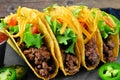 Group of ground beef hard shelled tacos close up