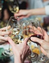 Group of guests celebrate and raise glasses, toasting and cheering with alcohol glasses with wine and champagne in the restaurant Royalty Free Stock Photo