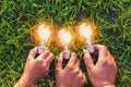 group hand holding lightbulb with sunset on grass. concept idea Royalty Free Stock Photo