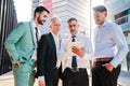 Group of handsome startup businessmen team work with suit using a tablet device at work space office buildings Royalty Free Stock Photo