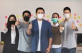 Group of Happy Asian business men leader standing making thumbs up with Business team at Co-Working space fight due COVID-19 virus Royalty Free Stock Photo