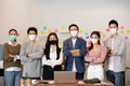 Group of Happy Asian business men leader standing wearing mask smile cross arm confidence with Business team at Co-Working space Royalty Free Stock Photo