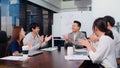 Group of happy Asian business people discuss together in team brainstorm meeting and clap hand, work late night in office