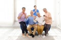 Group of happy Asian elderly senior people standing and sitting on the sofa while holding credit cards with a woman nurse. Royalty Free Stock Photo