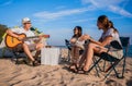 Group of happy Asian friends playing guitar and singing with clapping together having fun and enjoying while camping picnic on the Royalty Free Stock Photo