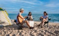 Group of happy Asian friends playing guitar and singing with clapping together having fun and enjoying while camping picnic on the Royalty Free Stock Photo