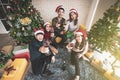 Group of happy Asian male female friends wear Santa Claus hat and reindeer antler headband together celebrating Christmas eve Royalty Free Stock Photo