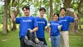 A group of happy Asian volunteers with garbage bags are standing in the public park Royalty Free Stock Photo