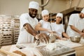 group of happy baking manufacture workers kneading