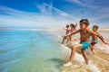 Many cute kids run to ocean waves on a beach Royalty Free Stock Photo