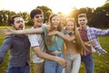 Group of happy and carefree young friends who are laughing in summer park with open arms to camera. Royalty Free Stock Photo