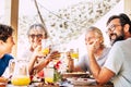 Group of happy caucasian people with different ages and generations enjoy and have fun together eating at the table - food and Royalty Free Stock Photo