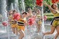 Group of happy Cheerleaders enjoy jogging through the fountain