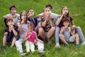 Group Of Happy Children Having Fun Outdoors, Sitting On The Grass And Blowing Dandelion Flowers At Sunny Spring Day Royalty Free Stock Photo