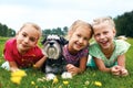 Group of happy children playing on green grass in spring park Royalty Free Stock Photo