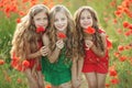 Group of happy children playing outdoors. Children have fun in the spring park. Girls run in the field with poppies. Royalty Free Stock Photo