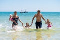 Group of happy children playing and splashing in the sea beach. Kids having fun outdoors. Summer vacation and healthy Royalty Free Stock Photo