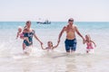 Group of happy children playing and splashing in the sea beach. Kids having fun outdoors. Summer vacation and healthy Royalty Free Stock Photo