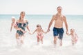 Group of happy children playing and splashing in the sea beach. Kids having fun outdoors. Summer vacation and healthy Royalty Free Stock Photo