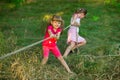 Group of happy children playing tug of war outside on grass. Kids pulling rope at park Royalty Free Stock Photo
