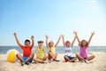 Group of happy children sitting on sand at sea beach. Summer camp Royalty Free Stock Photo