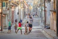 several children playing ball in the middle of an alleyway in cuba