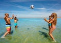 Group of happy cute kids play volleyball in water