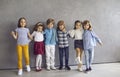 Group of happy cute young children in casual clothes standing together in studio Royalty Free Stock Photo