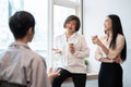 Group of happy diverse Asian businesspeople colleagues are enjoying talking during a coffee break Royalty Free Stock Photo