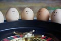 Group of happy eggs friends  make bets gambiling at the toy roulette in the toy casino Royalty Free Stock Photo