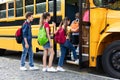 Group of happy excited children boarding yellow school bus Royalty Free Stock Photo