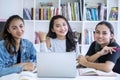 Group of happy female teenagers studying in library Royalty Free Stock Photo