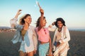 Happy friend walking on beautiful beach in summer sunset in their hands is smoke fontain Royalty Free Stock Photo