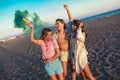 Happy friend walking on beautiful beach in summer sunset in their hands is smoke fontain Royalty Free Stock Photo