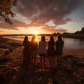 Group of happy friends chatting in front of the sunset with their backs to the camera. Travel, people, leisure and teenager. Royalty Free Stock Photo