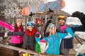 Group of happy friends on cold winter day at mountain cottage an