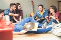 Group of happy friends doing party listening vintage vinyl disc at home - Young people having fun drinking shots Royalty Free Stock Photo