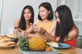 Group of happy friends eating dinner together and woman taking photo of food on the table