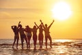 Group of happy friends embrace at sunset beach Royalty Free Stock Photo