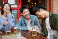 Group of happy friends are enjoying talking and drinking beers while hanging out at a restaurant