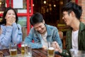 Group of happy friends are enjoying talking and drinking beers while hanging out at a restaurant